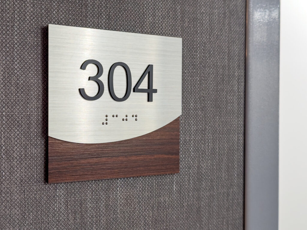 Photos of a brown and silver hotel room number 304 with braille.