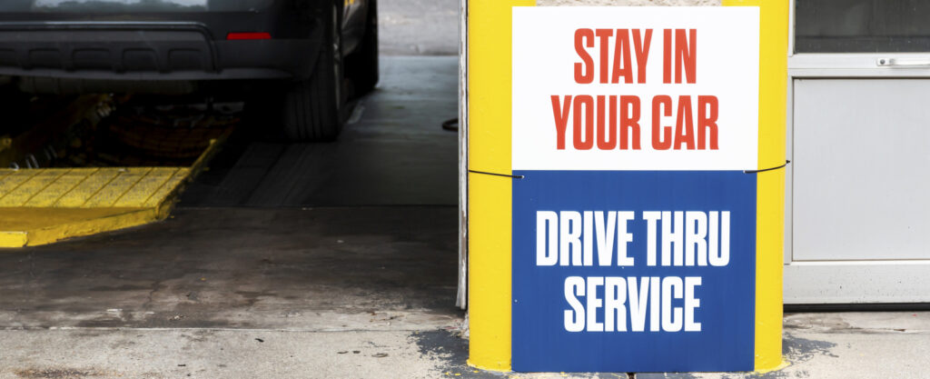 Stay in your car for drive though oil change service sign