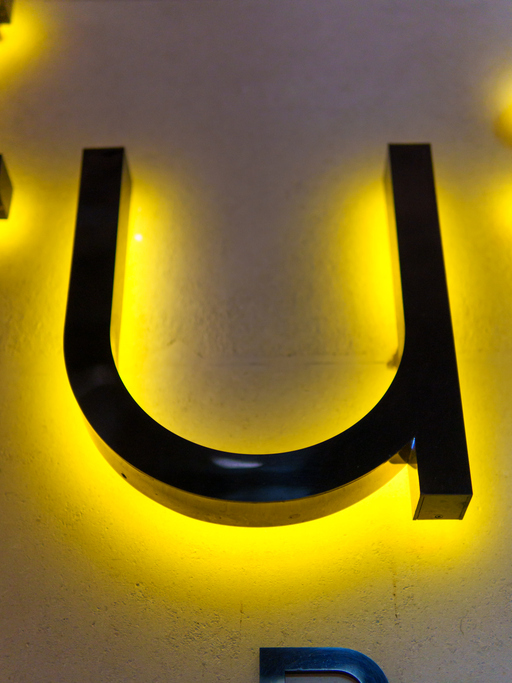 Bright illuminated U letter on wall creates striking visual effect at night